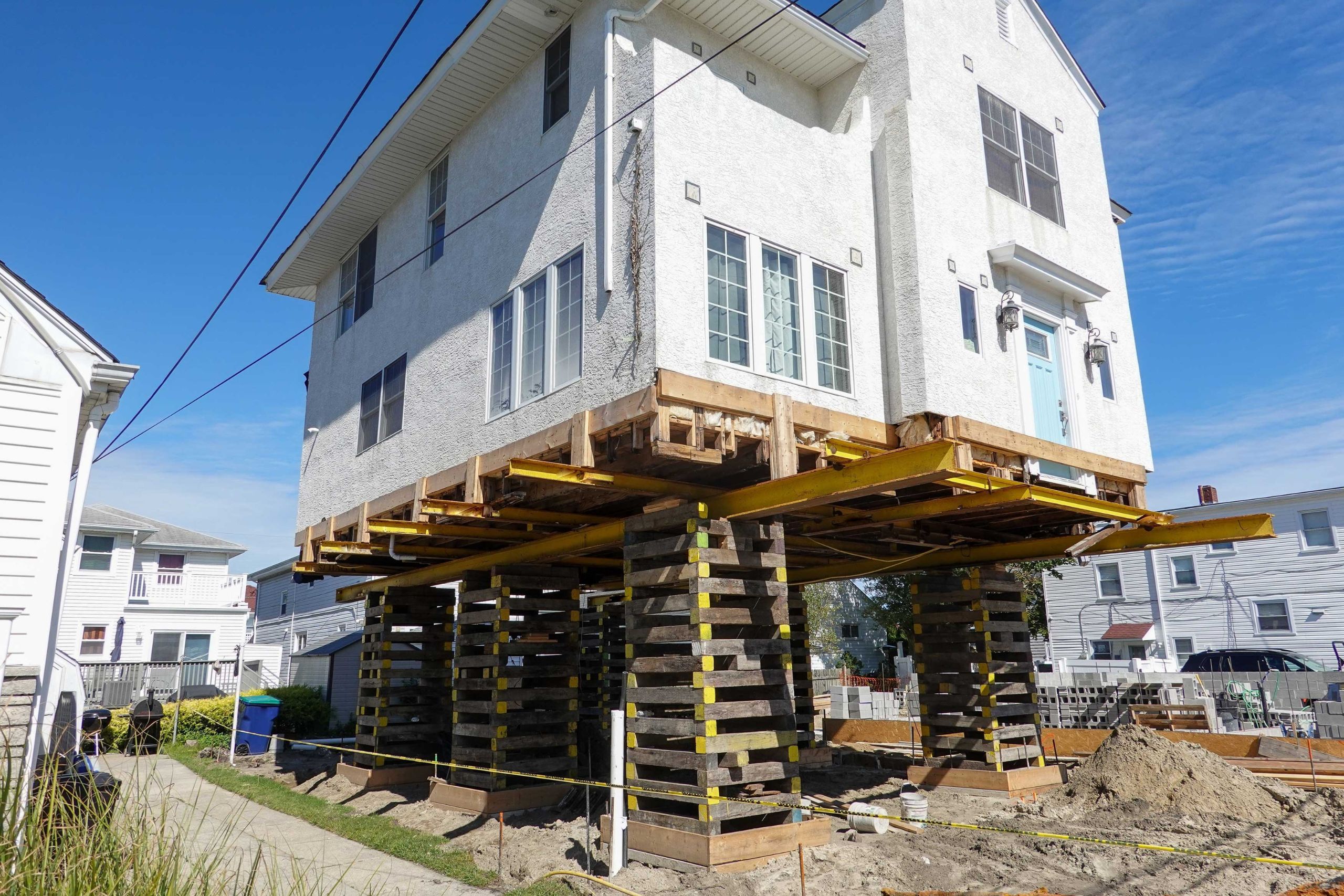 A team of professionals using specialized equipment to raise a house in Boston, preparing it for elevation and renovation